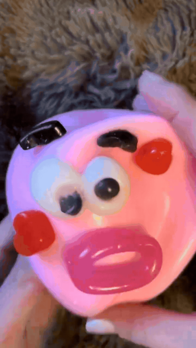 Funny face squishy stress ball being squeezed